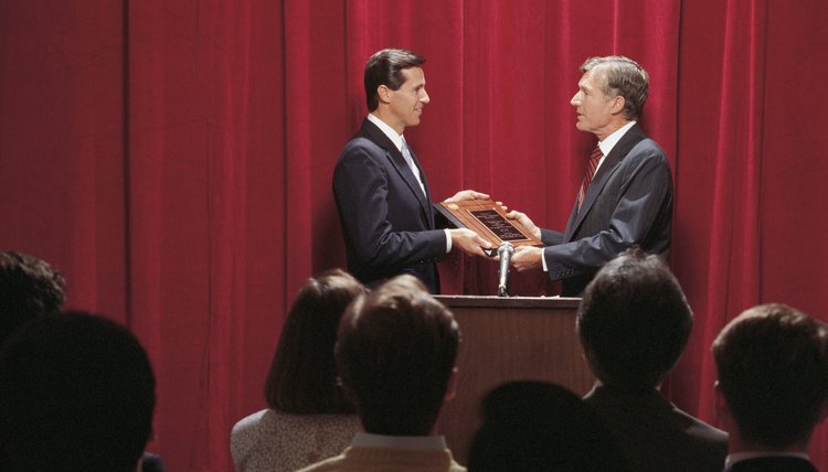 A man is handing someone a plaque.