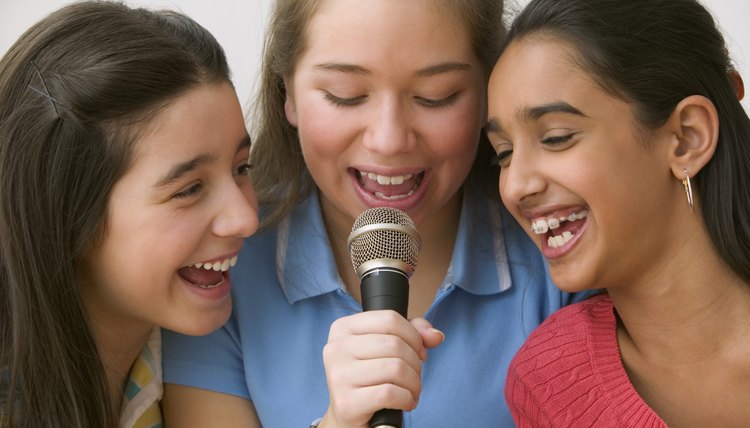Girls singing into microphone