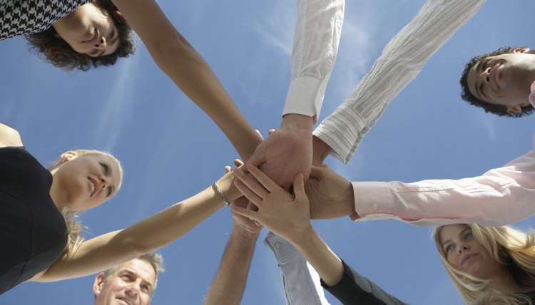 Group of people holding hands in circle, low angle view