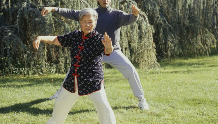 Man and woman practising tai chi in park