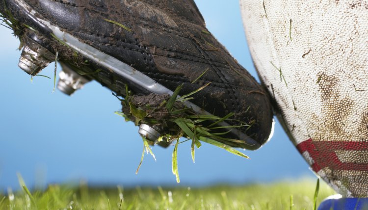 Rugby player kicking ball off tee, close up of foot