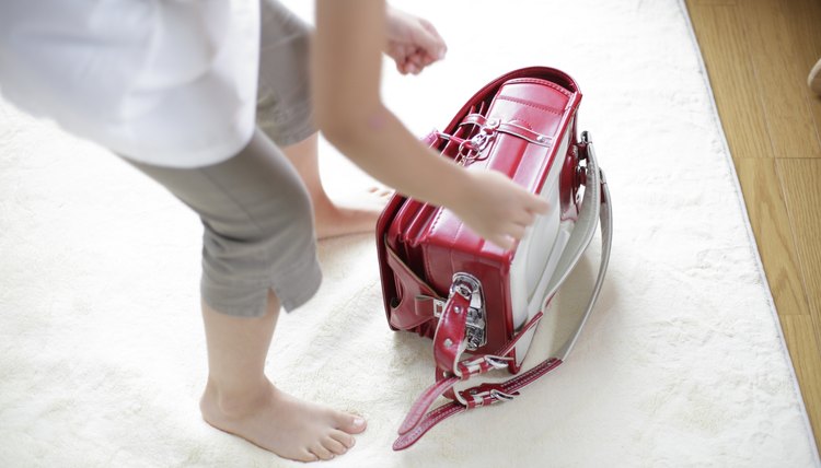 Young girl grabbing her backpack.