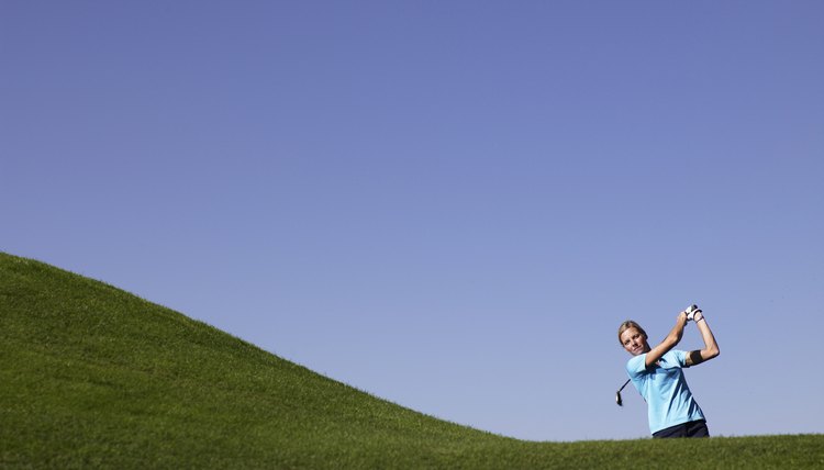 Woman swinging at golf course