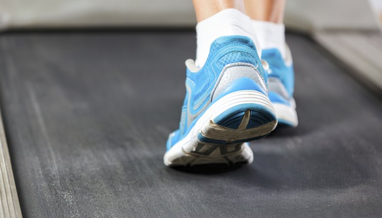 Woman running on treadmill in gym.