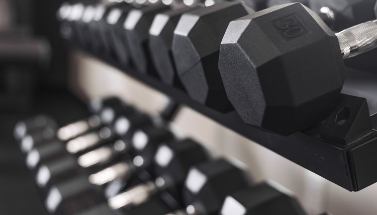 rack of desaturated dumbbell weights in gym