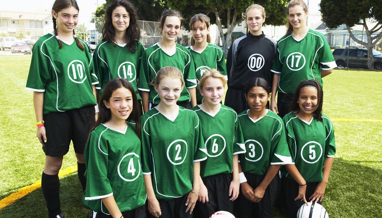 Portrait of girls (12-15) football team, smiling