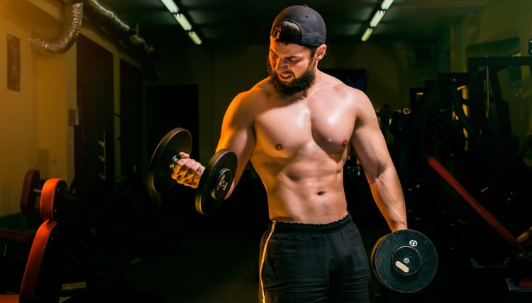 man in gym training with dumbbells