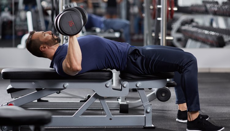 This man shows off the starting position of a supine dumbbell press.