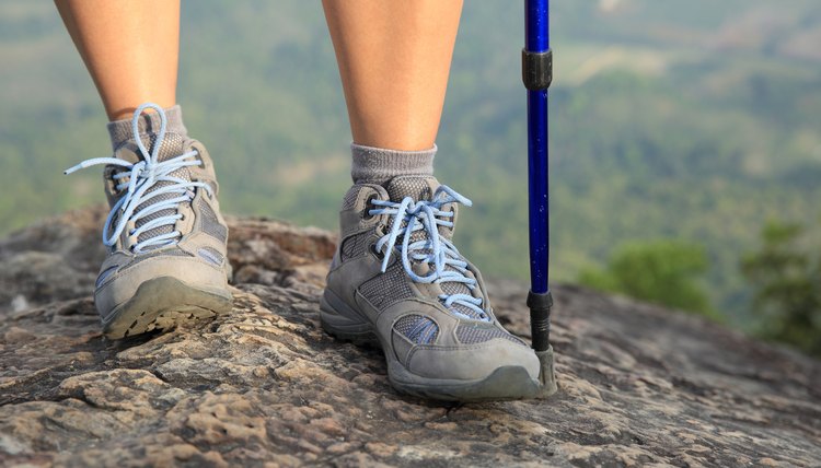 young woman hiker legs on mountain peak cliff