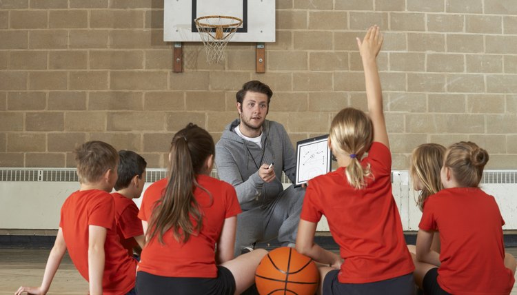 Coach Giving Team Talk To Elementary School Basketball Team