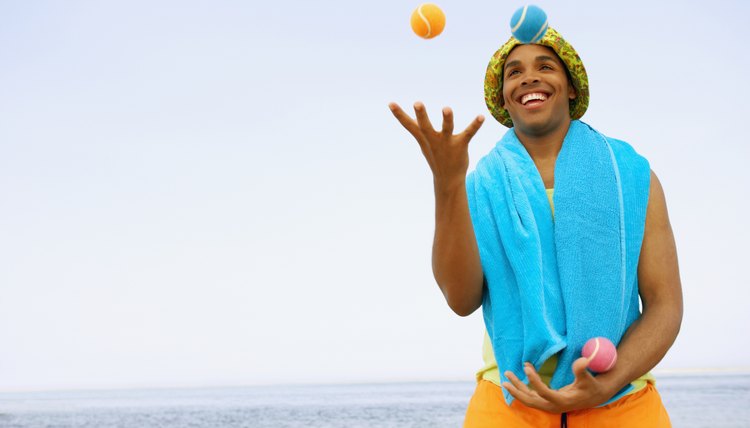 Hispanic man juggling at beach