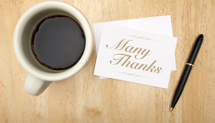 Thank you note and pen next to a cup of coffee