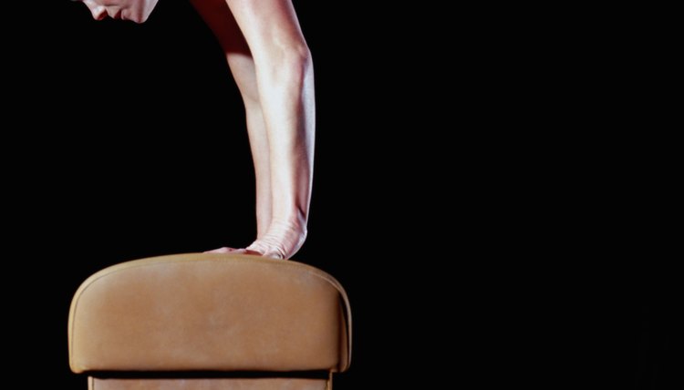 Female gymnast balanced on vault, side view