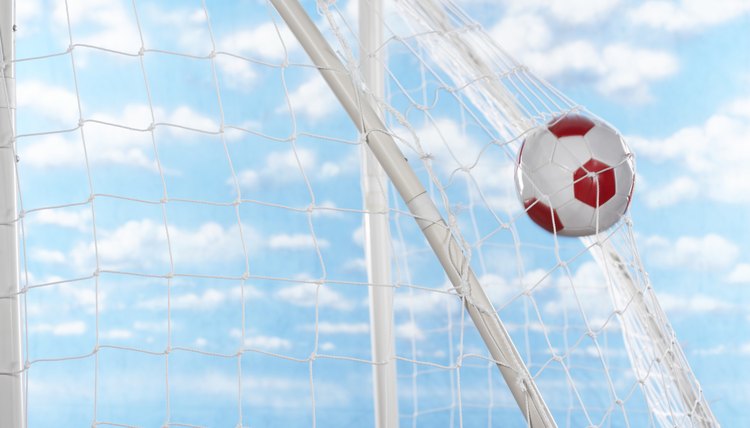 Soccer ball hitting back of net of goal