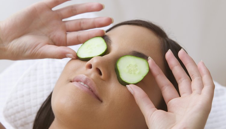 Young woman resting with cucumbers on her eyes