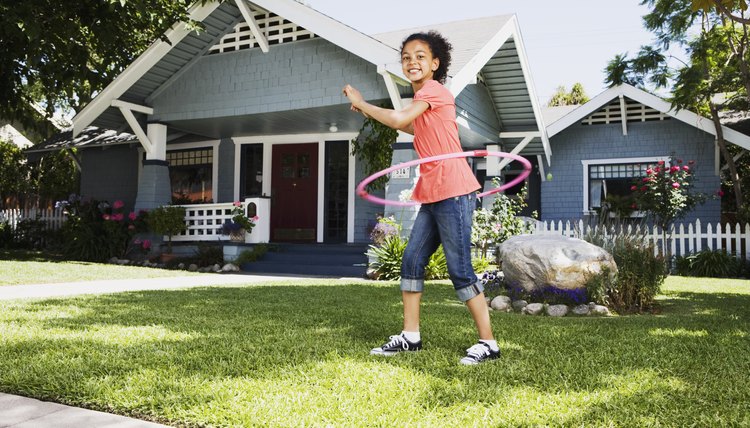 Young girl playing with a hula hoop.