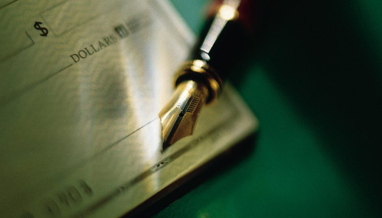 Close-up of checkbook and fountain pen