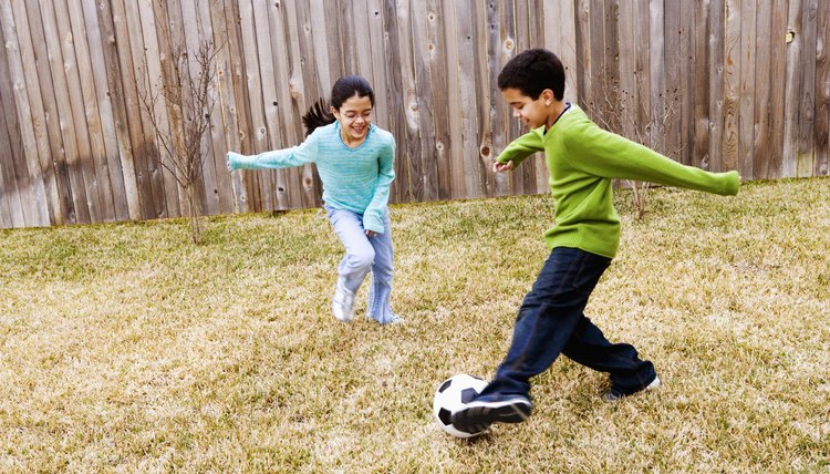 Children ( 8-11)  playing football in ground