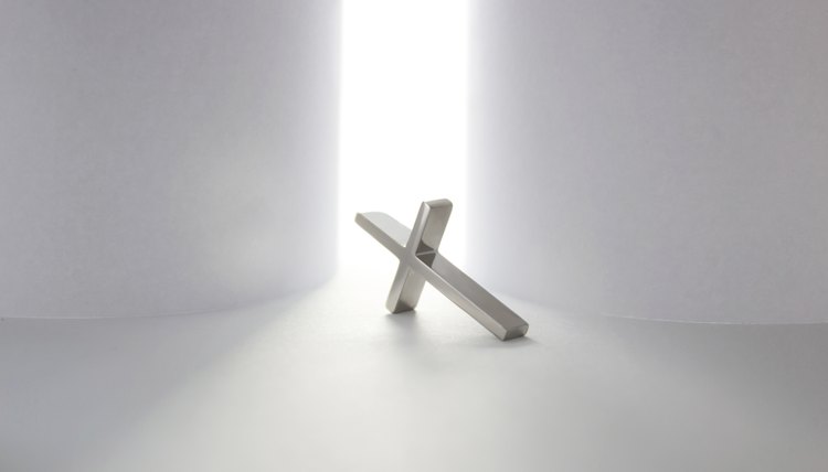 Cross laying in front of bright light.