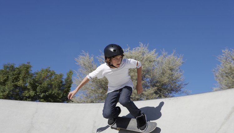 Teenage boy (16-17) skateboarding at skate park