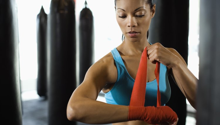 Serious woman wrapping wrists