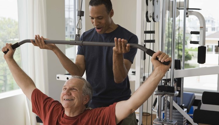 Personal trainer with man in home gym