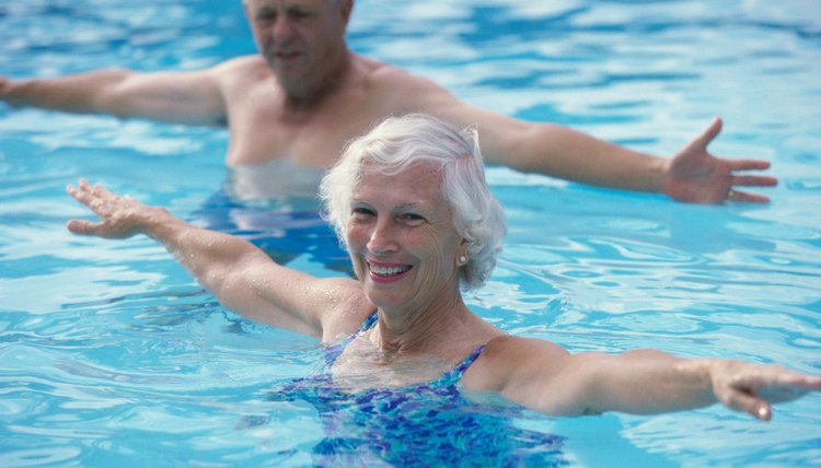 Portrait of a senior couple stretching in a swimming pool