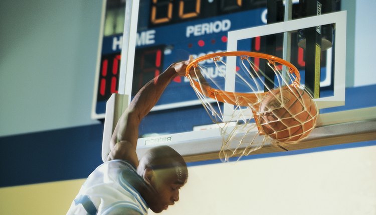 Man slam dunking basketball