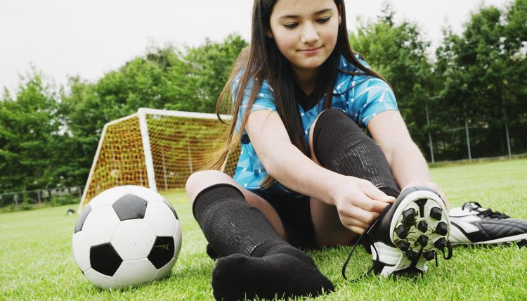 Girl tying soccer cleat