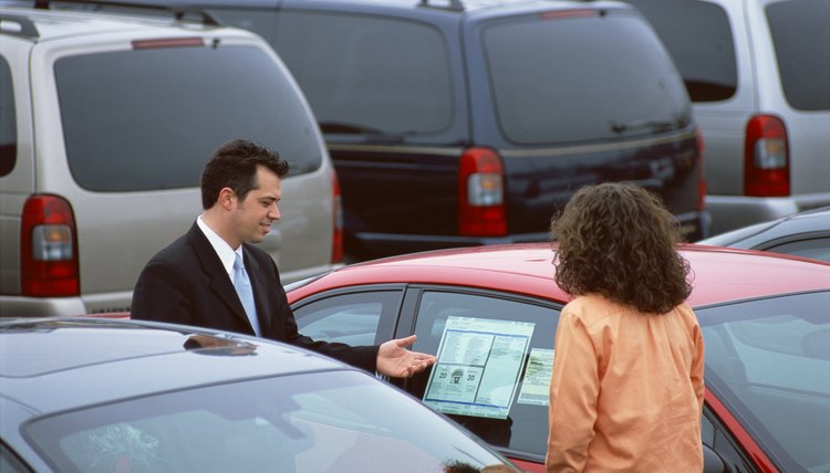 Man showing woman a car for sale