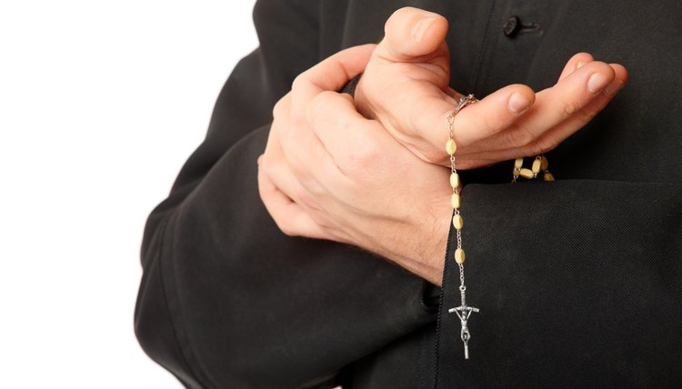 Catholic priest holding a rosary.