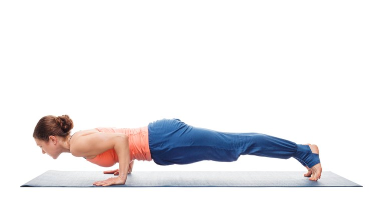 Woman doing Ashtanga Vinyasa Yoga asana Chaturanga Dandasana - four-limbed staff pose posture isolated on white background