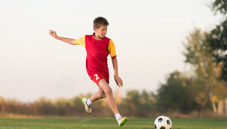 kid kicking a soccer ball