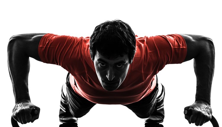 one man exercising fitness workout push ups in silhouette on white background