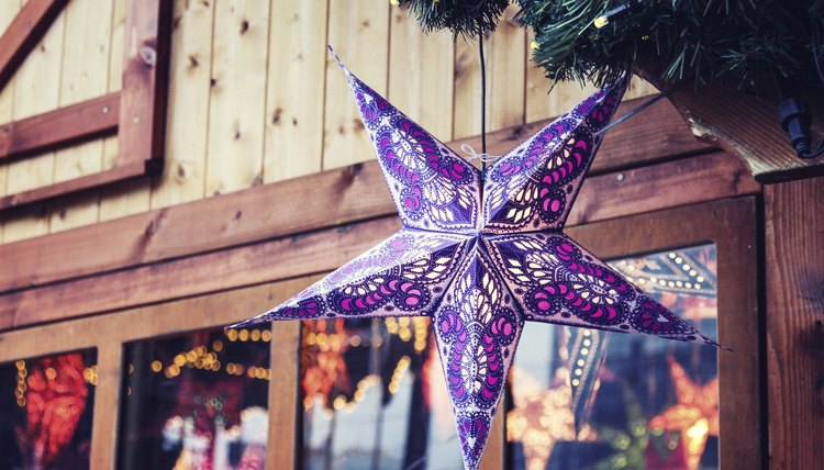 Strings of moravian stars hanging in a rustic storefront.