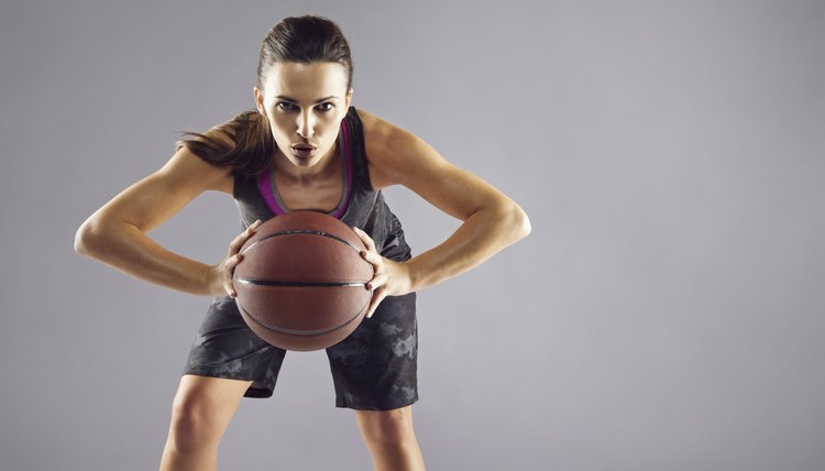 Beautiful woman in sportswear playing basketball
