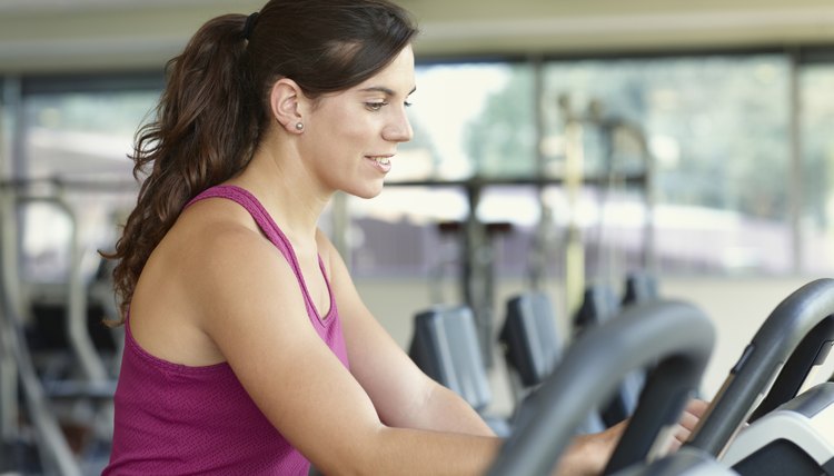 Young woman adjusting the treadmill