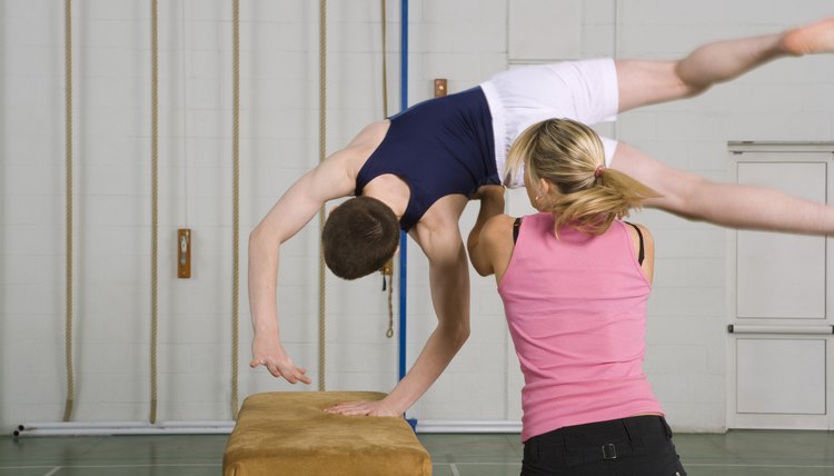 Coach helping gymnast cartwheel