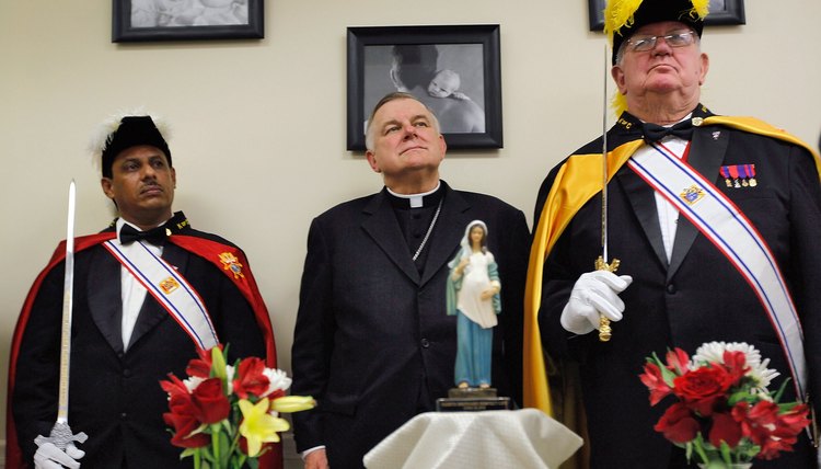 The Miami archbishop is flanked by two members of the Knights of Columbus, a Catholic fraternal order.