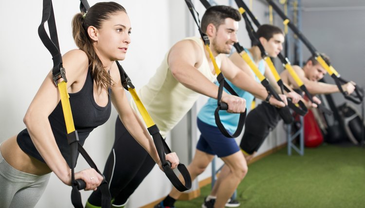 People at gym doing elastic rope exercises