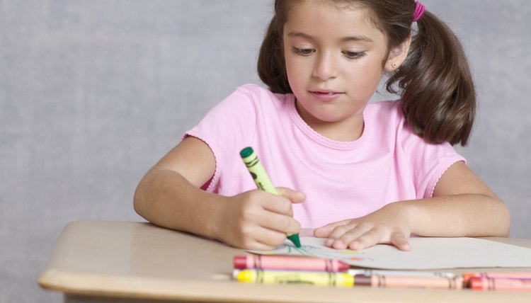 Young girl coloring at table.