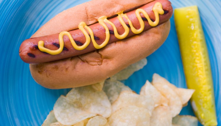 High angle view of hot dog with chips and pickle on plate