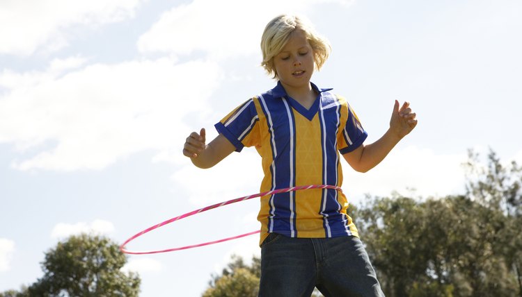 Boy (12-13) playing with plastic hoop in park