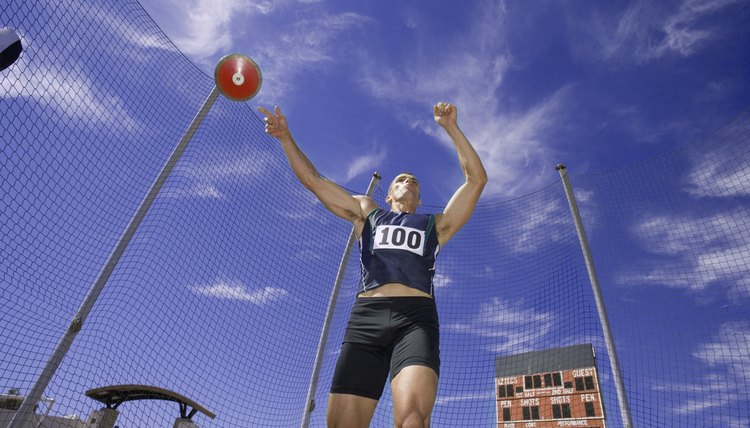 Male athlete throwing discus, low angle view