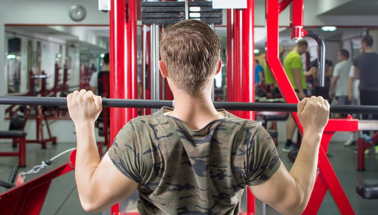 Muscular man performing lat pulldown at the gym