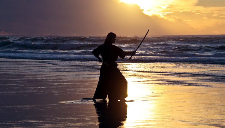 Young samurai women with Japanese sword on the beach