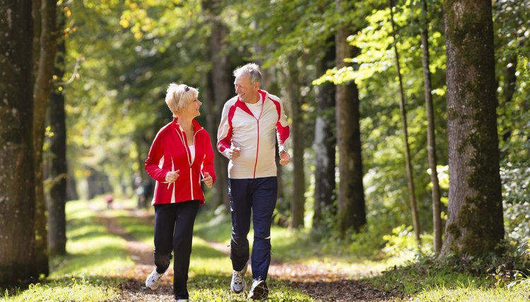 Seniors jogging on a forest road
