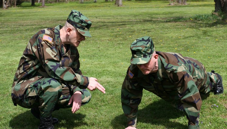 A sergeant instructs a soldier to do pushups. (This image was created by merging two photographs of the same model.)