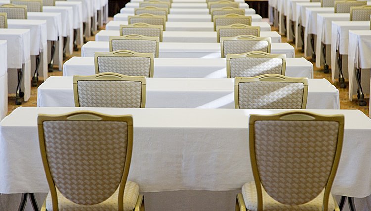 Rows of chairs and tables set up at an event.