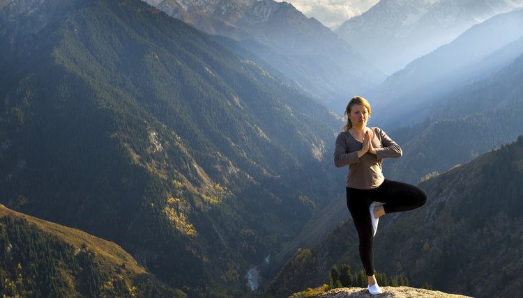 Woman doing yoga on a mountain summit